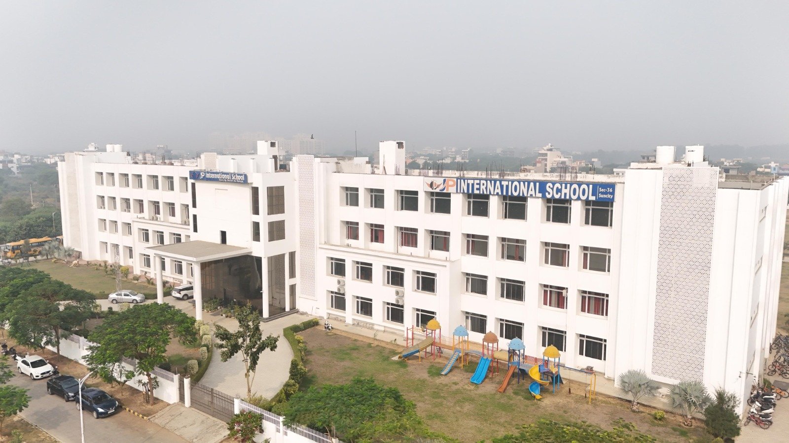 Modern multi-storey school building and lush green campus in Rohtak