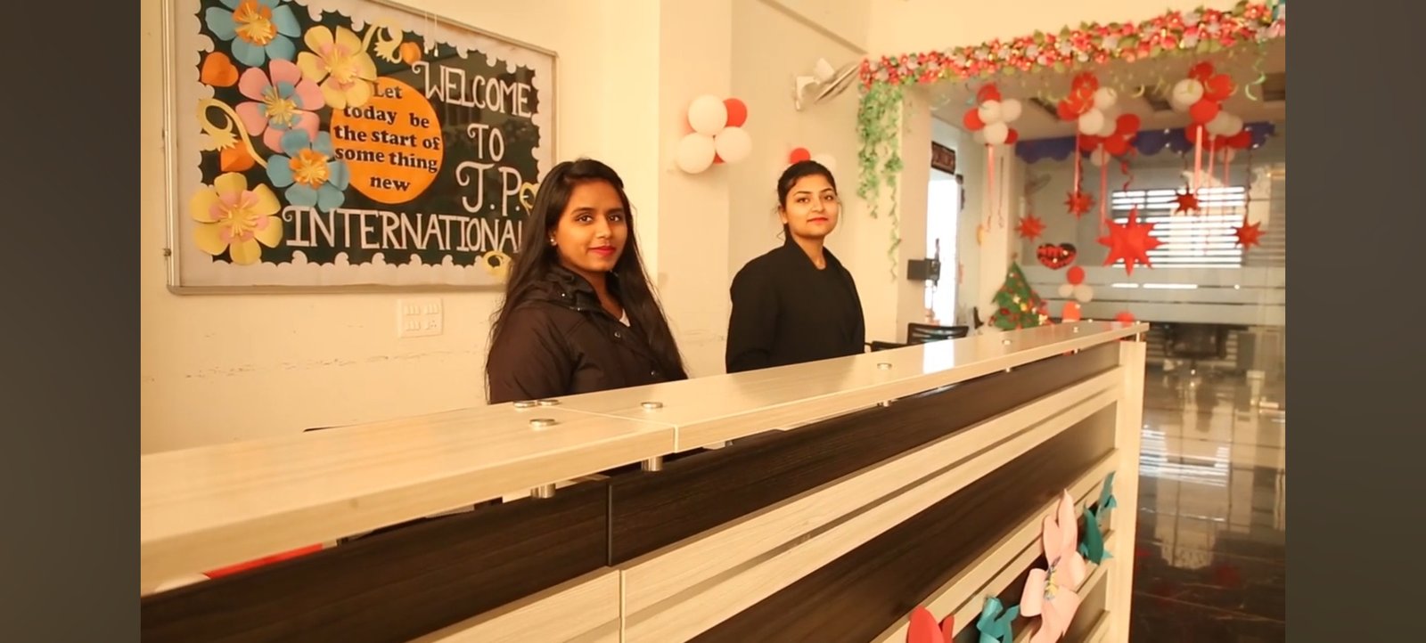 Reception desk and administrative staff welcoming visitors at JP International School lobby